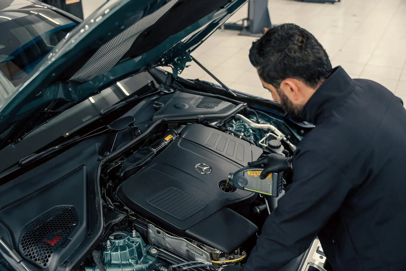 A mechanic inspecting a car engine with the bonnet open